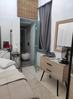 a bedroom with a bed and a desk with a mirror at Porto Chania in Chania Town