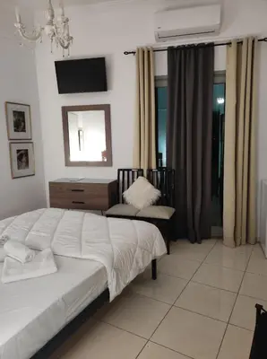 a bedroom with a large bed and a chair at Porto Chania in Chania Town