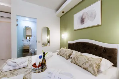 a bedroom with a white bed and a bathroom at Konmari Boutique Suites in Chania Town