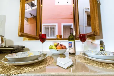 a table with two glasses of wine and a bowl of fruit at Konmari Boutique Suites in Chania Town
