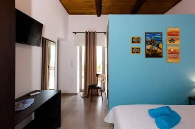 a bedroom with a bed and a blue wall at M & E Kissamos sea view house in Kissamos