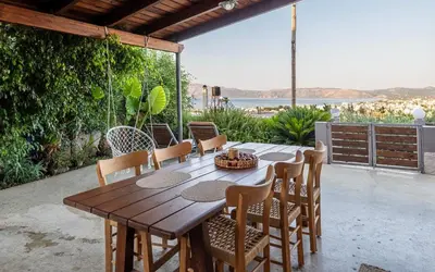 a wooden table and chairs on a patio at M & E Kissamos sea view house in Kissamos