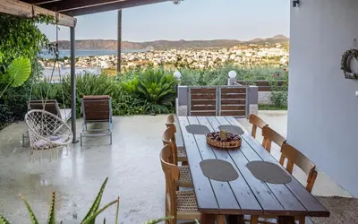 a wooden table and chairs on a patio at M & E Kissamos sea view house in Kissamos