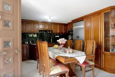 a kitchen with a table and some wooden cabinets at Apartment with Premium Facilities in Chania Town