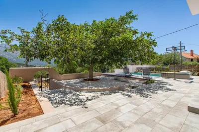 a patio with a tree and a pool at Villa Skyphos in Ammoudari