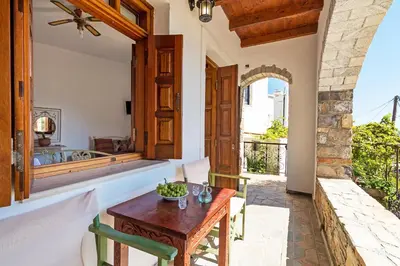 a dining room with a table and a balcony at VENTUS Studios in Khóra Sfakíon