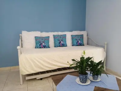 a blue bedroom with a bed with four pillows at Nikoleta Apartment in Chania Town