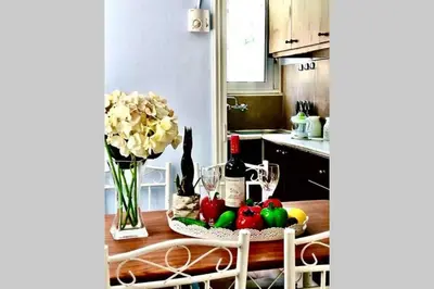 a kitchen with a table with fruit and wine bottles at Nikoleta Apartment in Chania Town