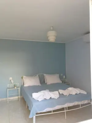 a bed in a room with a blue wall at Nikoleta Apartment in Chania Town
