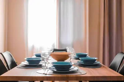 a wooden table with plates and bowls and wine glasses at Calme luxury residence in Chania Town