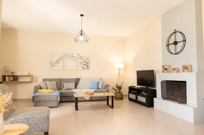 a living room with a couch and a tv at Calme luxury residence in Chania Town