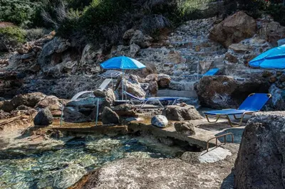 a group of chairs and umbrellas in the water at House with Private Place To Swim, Solitary, View in Ravdhoúkha
