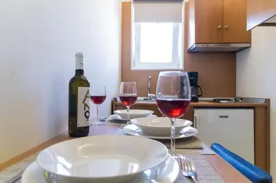 a table with wine glasses and a bottle of wine at Irene Suite Chania in Kato Daratso