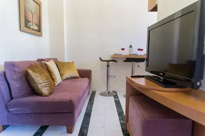 a living room with a purple couch and a flat screen tv at Irene Suite Chania in Kato Daratso