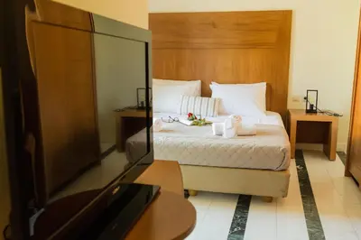 a hotel room with a bed and a tv at Irene Suite Chania in Kato Daratso