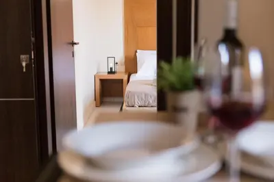 a room with a bed and a table with a glass of wine at Nicky Apartments Chania in Chania Town