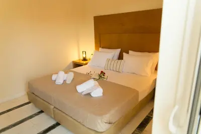 a hotel room with a bed with towels on it at Nicky Apartments Chania in Chania Town