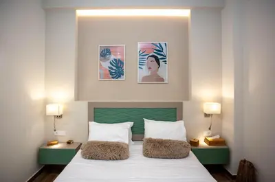 a bedroom with a bed and two pictures on the wall at Blue Jasmine Apartments in Chania Town