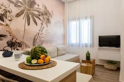 a living room with a table with a bowl of fruit at Blue Jasmine Apartments in Chania Town