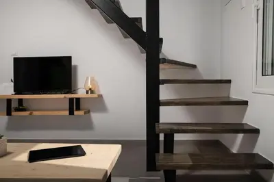 a living room with a staircase and a television at 