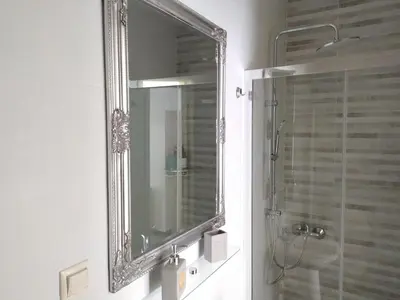 a mirror on a wall in a bathroom at Chania 1548 Old Town Apartments in Chania Town