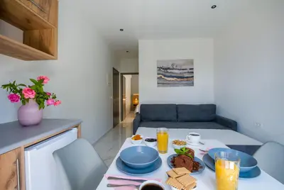 a table with food on it in a living room at Linda Apartments Platanias in Plataniás