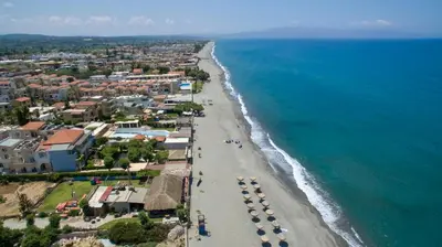 an aerial view of a beach with umbrellas and the ocean at Linda Apartments Platanias in Plataniás