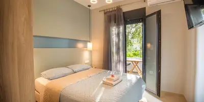 a hotel room with a bed with a balcony at On the sand 1 in Palaiochóra