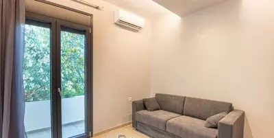a living room with a couch and a large window at On the sand 1 in Palaiochóra