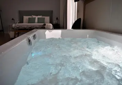 a tub filled with blue water in a bedroom at Balance Hotel in Chania Town