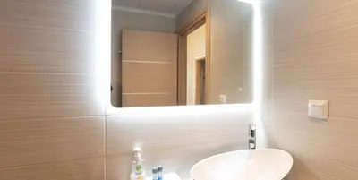 a bathroom with a white sink and a mirror at On the sand 2 in Palaiochóra