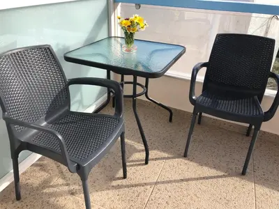 two chairs and a table with a vase of flowers at Faros apartment in Sfakiá