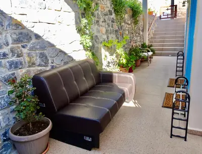 a leather couch sitting in a hallway with plants at Faros apartment in Sfakiá
