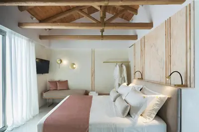 a bedroom with a large white bed and a couch at Mirabile Luxury Suites in Chania Town