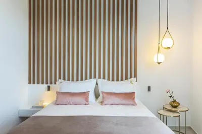 a bedroom with a bed with two pink pillows at Mirabile Luxury Suites in Chania Town