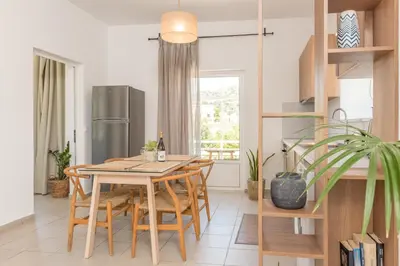 a kitchen with a table and chairs and a refrigerator at eden of grameno in Palaiochóra
