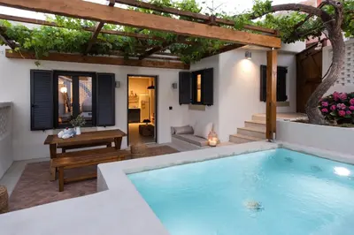 a pool in the backyard of a house with a pergola at Cretan Soul in Plataniás