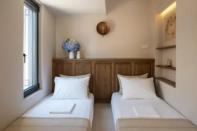 two beds in a small room with a window at Cretan Soul in Plataniás