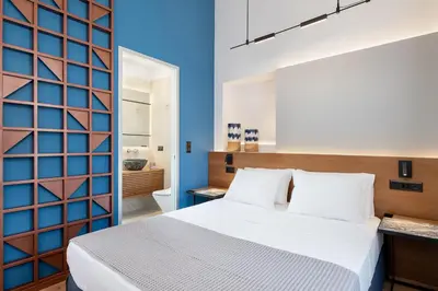 a bedroom with a white bed and a blue wall at Camere Maritima in Chania Town