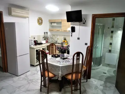 a kitchen with a table with chairs and a refrigerator at Matzi House in Chania Town