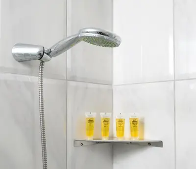 a shower with four glasses of beer on a shelf at Matzi House in Chania Town