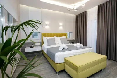 a bedroom with a large bed with a yellow headboard at Limosa Luxury Residences in Kissamos