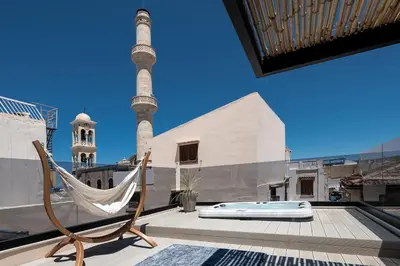 a hammock on the roof of a building with a mosque at Agazade Bey in Chania Town