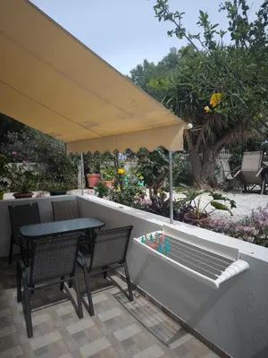 a patio with a table and chairs and an umbrella at Alexia Rooms in Palaiochóra