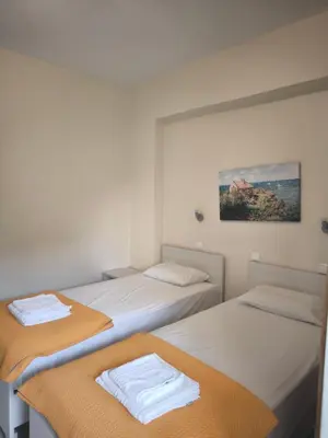 a room with two beds with towels on them at Alexia Rooms in Palaiochóra