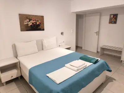 a bedroom with a bed with a blue and white blanket at Alexia Rooms in Palaiochóra