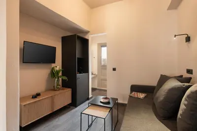 a living room with a couch and a tv at Anaem Eclectic Rooms in Chania Town