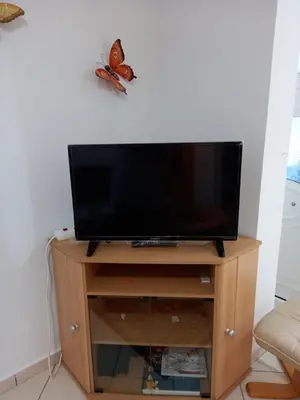 a flat screen tv on a wooden stand at Alexandros cosy house for family vacation in Chania Town
