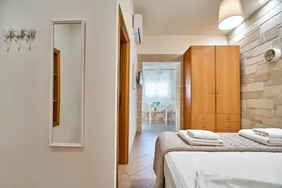 a bedroom with two beds and a room with a table at Semeli Apartment in Kissamos