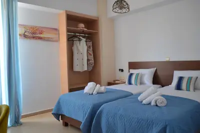 a bedroom with two beds with blue sheets and towels at Vitro art House-in the heart of Chania in Chania Town